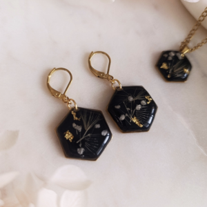 Tento elegantný čierny set je vytvorený z čiernej živice, ktorá necháva naplno vyniknúť krehkú krásu bielej gypsomilky a jemného plátkového zlata